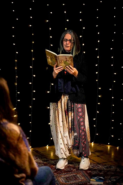 A woman reads from a notebook