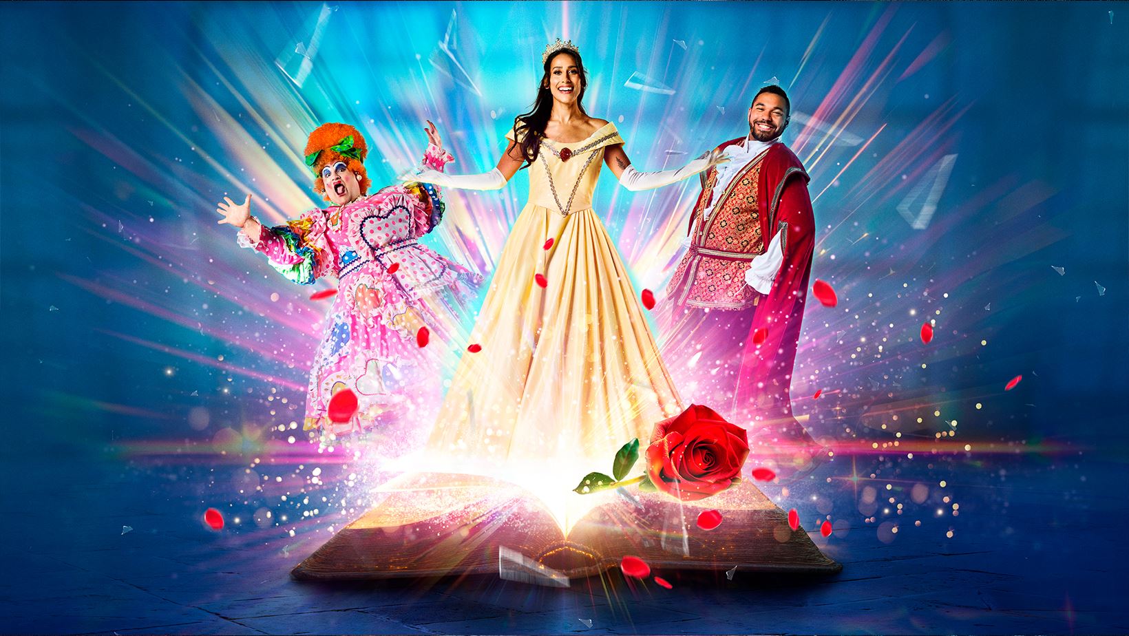 Colourful promotional image for a theatrical production of Beauty and the Beast. A glowing storybook opens at the bottom, emitting sparkling light and rose petals. In the centre stands a smiling woman dressed as Belle in a golden gown and tiara. To her left is a flamboyantly dressed panto dame in a brightly coloured costume and orange wig. To her right stands a man in an ornate red and gold princely outfit. 